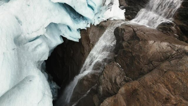 glacier with a waterfall and a large ice hole in the rocks, Briksdalsbreen, norway, nature, drone