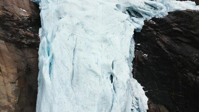 close -up of a huge glacier between the rocks of a mountain, Briksdalsbreen, norway, nature, drone