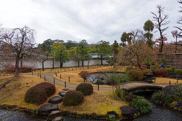 Park with plants at famous Unesco Word Heritage site Himeji-jo castle on a cloudy gray winter day. Photo taken February 1st, 2024, Himeji, Japan.