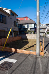 Cityscape with road and building lot with construction barrier at metropolis of Tokyo on a sunny winter day. Photo taken January 27th, 2024, Tokyo, Japan.