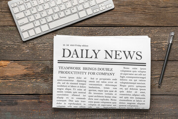 Newspaper with keyboard and pen on wooden background - obrazy, fototapety, plakaty