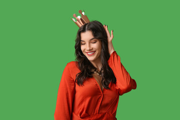 Beautiful young woman in stylish prom dress and paper crown on green background © Pixel-Shot