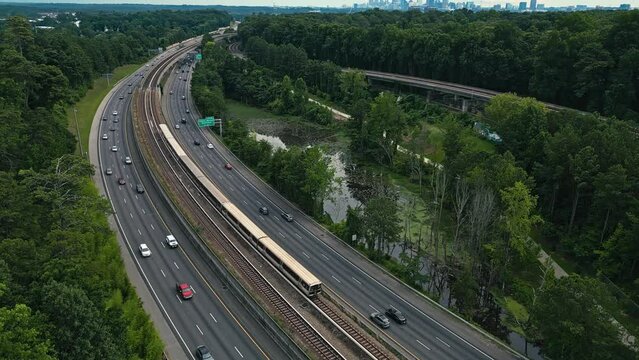 Train And Cars Passing Through Georgia State Route 400 With PATH400 In Buckhead, Atlanta, Georgia. - aerial shot