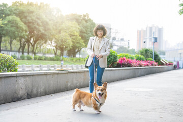 Woman holding a corgi dog
