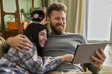 love happy couple use tablet pad together lying on couch