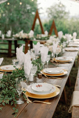 Outdoor wedding table with lush greenery and gold details
