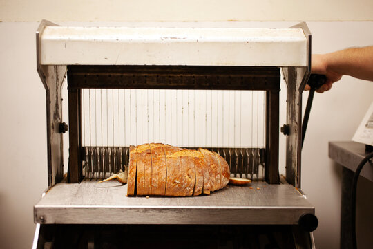 Bread maker slicing bread on machine