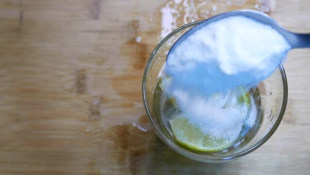 Macerating a caipirinha. Adding sugar to a caipirinha glass with lemons. Preparing a lemon cocktail. Caipirinha drink on the cutting board. Mixing sugar and lemon. Preparing a caipirinha. Drinking day