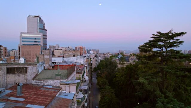 Aerial Drone Fly above Fine Arts neighborhood in Santiago de Chile Sunset Moon Skyline with vibrant colors, houses in latin american cityscape