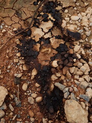 Abstract background Pebbles, rock and stones at a beach contaminated with toxic chemical gasoline oil waste releasing hazardous chemicals into the environment.