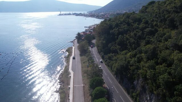 Drone Shot of Traffic on Coastal Road in Kotor Bay, Boka Kotorska, Montenegro. Scenic Route on Summer Day