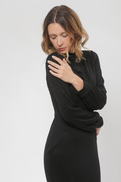 Serie of studio photos of female model in knitted black midi dress, autumn winter fashion collection