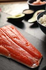 Fresh salmon for sushi on dark table, closeup