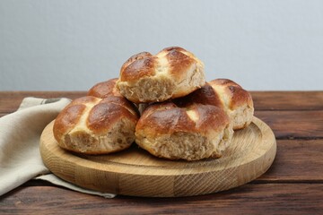 Tasty hot cross buns on wooden table