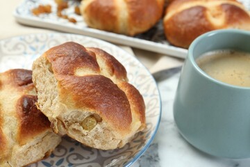 Hot cross buns and coffee on white marble table, closeup