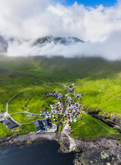 Drone view of Village of Gjogv on Faroe Islands with colourful houses. Mountain landscape with ocean coast