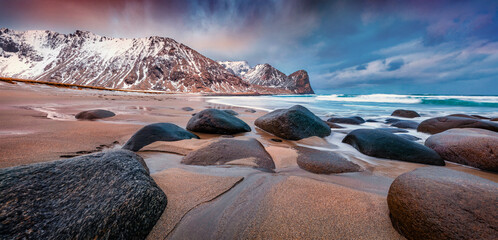 Big boulders on the coast of Norwegian sea. Panoramic spring view of Unstad Beach. Great sunrise...