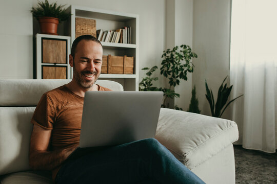 Happy man watching movie on laptop at home