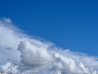 White fluffy cumulus clouds in the summer sky, natural clouds background