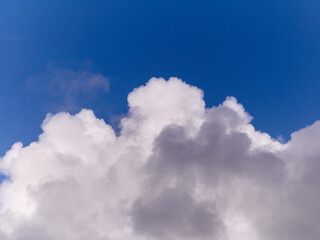 White cumulus clouds in the deep blue summer sky. Fluffy clouds background