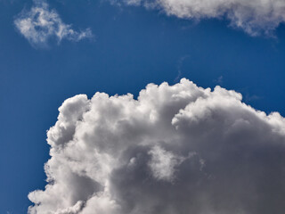 White cumulus clouds in the deep blue summer sky. Fluffy clouds background