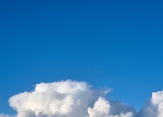 White fluffy cumulus clouds in the summer sky, natural clouds background