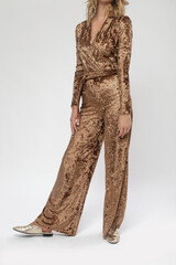 Serie of studio photos of female model in golden colored plush jumpsuit