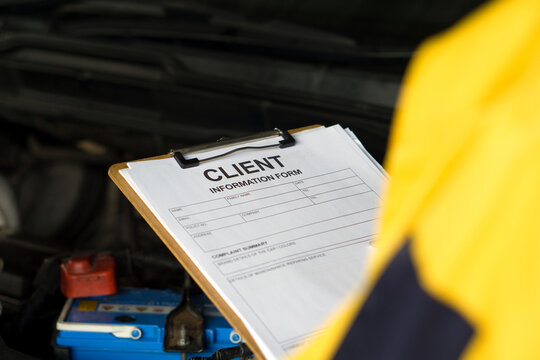 A man holds a clipboard featuring a form with client detail, ready to be filled out.