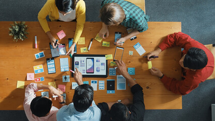 Top view of software developer team looking Ux Ui design for mobile phone interface from tablet...