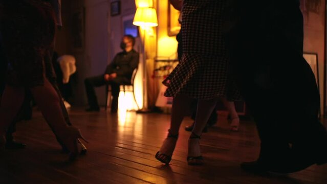 foot steps in the floor of a milonga dancing Argentine Tango in a moody bar cafe	