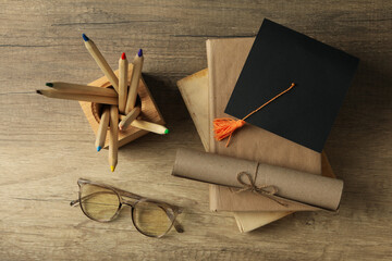 Graduate hat and books on wooden table