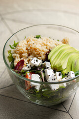 Salad with quinoa, avocado and feta cheese in a glass bowl