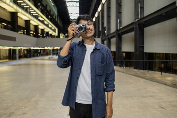 tourist man looking through his camera in indoor museum centertourist man with his analog camera looking through the viewfinder