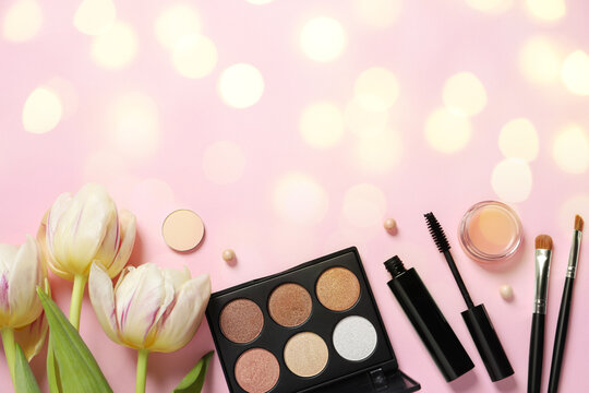 Different makeup products and beautiful tulip flowers on pink background with space for text, flat lay. Bokeh effect