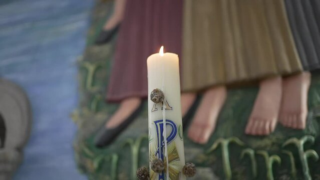 Lit paschal candle with alpha and omega
