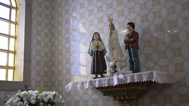 Pastorinhos of F&aacute;tima and Virgin Mary statues in church