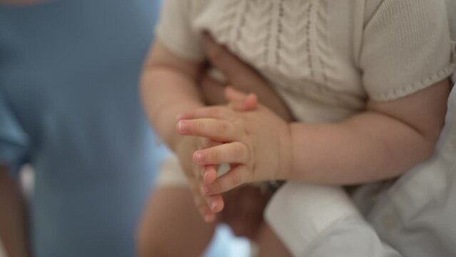 Clasped hands of mother and baby