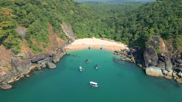Aerial view of secret beach Butterfly in Goa, India with rocky bay and boats