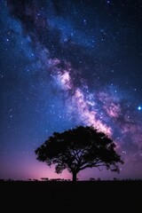 Majestic night sky with the Milky Way galaxy arching over a lone tree in an open field.