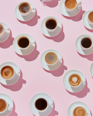 A flat lay of coffee cups arranged in an aesthetically pleasing pattern on a pink background, different types of espresso. Cosmetic background.