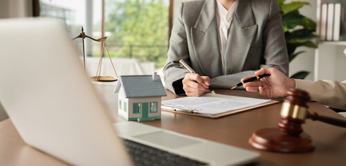 Lawyer and businesswoman signing a business contract regarding real estate law and property...
