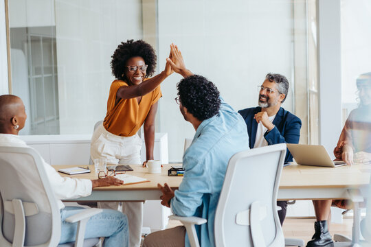 Successful business team celebrating a project in a boardroom - Powered by Adobe
