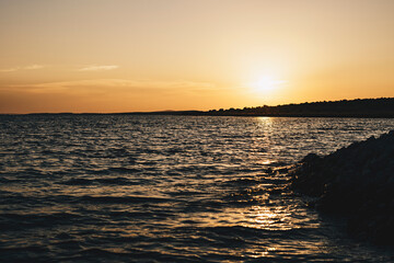Sunset over island on Mediterranean Sea during summer season