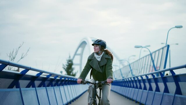 Young urban woman traveling around the city by bike, cycling to work, university to save money. Concept of bike commuting in the city, sustainable lifestyle. - Powered by Adobe