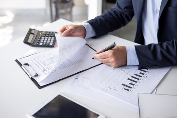 Business professional analyzing financial documents at desk