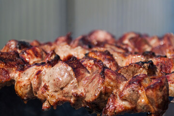 The meat is baked on a skewer on a skewer. Skewers background and texture. Delicious meat with skin.