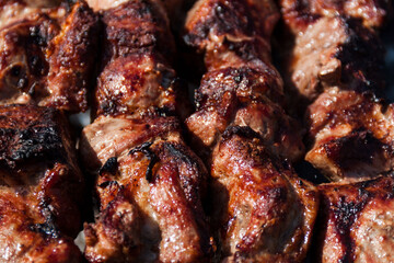 The meat is baked on a skewer on a skewer. Skewers background and texture. Delicious meat with skin.