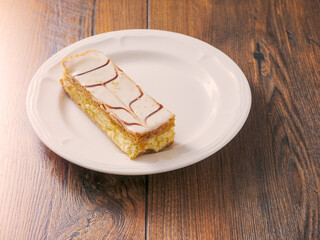 Plate with portion of cram cake on wooden table. Bakery fine product and dessert.