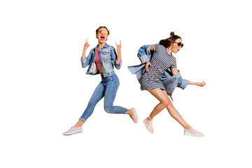 Full legs body size beautiful gorgeous adorable two lady isolated on yellow background in trendy casual street style stylish denim jeans wear glasses spectacles give heavy metal gesture play guitar
