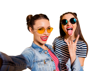 Carefree careless funny glad two girlish lady isolated on yellow shine background in trendy glasses spectacles take picture on cellular give heavy metal gesture show stick out